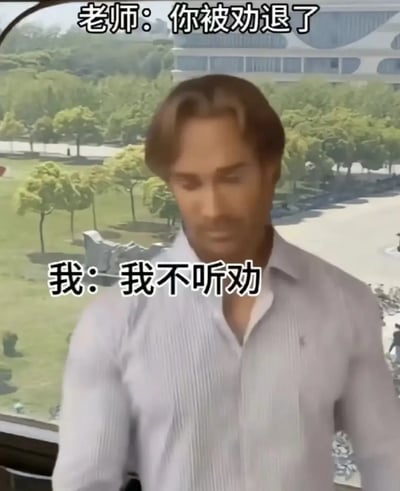 这张梗图展示了一名身穿白色衬衫的男性站在窗前，背景为校区景色，并配有搞笑对话：“老师：你被劝退了”，“我：我不听劝”。图片以学生面对被“劝退”时的无赖、倔强态度为笑点，展现出一种无视现实、强行无视规矩的幽默气质。对话有趣地利用了“劝退”“听劝”之间的双关关系，增加了谐音和语义梗的幽默效果。