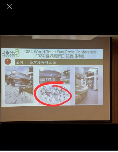 图片展示了2024年世界厕所日记者招待会的一个幻灯片，重点介绍获得金奖的荃湾海兴路公厕。幻灯片上包含三张图片：左侧是公厕的外观照片，中间是带有红色圆圈标记的平面图，右侧是公厕内部照片。整个画面呈现出正式的会议展示场景，突出了获奖公厕的设计特点。