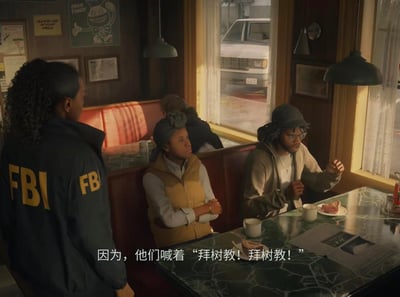 这是悬疑恐怖游戏《心灵杀手2》的3D渲染游戏场景截图：画面左侧是身着印有FBI标识外套的探员，正面向餐厅卡座上的两人；卡座上的女性双臂交叉，抬头注视探员，戴帽眼镜的男性则抬手做出手势，正在陈述信息。画面底部的中文字幕显示‘因为，他们喊着“拜树教！拜树教！”’，揭示对话围绕神秘的‘拜树教’展开。背景是暖光笼罩的复古餐厅，窗外可见停放的车辆，整体氛围在温暖的环境中透出悬疑调查的紧张感，对应游戏中探员追查邪教相关案件的剧情。