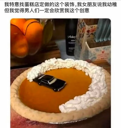 这是一张展示创意定制食物的图文内容，图中是一个表面为焦糖色的派，边缘挤有一圈白色奶油，派的表面放置了一辆黑色玩具小汽车，仿佛汽车行驶在道路上。上方配文表示，这是发布者特意找蛋糕店定做的装饰，女朋友觉得这个设计很幼稚，但发布者认为男性群体一定会喜欢这个结合了汽车元素的趣味创意。