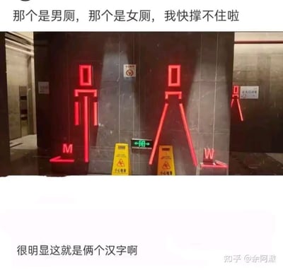 图片展示了一组设计独特的厕所标识场景。画面中央是两块深灰色墙壁，上面分别装有红色霓虹灯勾勒出的人形符号，左侧符号下方标有红色"M"字样及左箭头，右侧符号下方标有红色"W"字样。两个标识之间有一个绿色的双向箭头出口标志，下方放置着两个黄色的"小心地滑"警示牌。图片上方配有文字"那个是男厕，那个是女厕，我快撑不住啦"，表达出因标识设计可能带来的辨识困惑和急切心情；下方文字"很明显这就是俩汉字啊"则以幽默口吻暗示标识可能采用了汉字造型，增加了趣味性。
