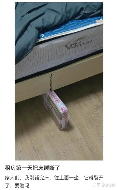 这是一张生活吐槽类搞笑图片，内容为在租房第一天刚铺好床，结果一坐上去床就裂开了，随后用快递箱子临时支撑维修。配文自嘲“要赔吗”，让人感受到生活的不易和无奈，带有强烈的“打工人自救”氛围，令人哭笑不得，无明显双关，但有鲜明自嘲氛围。