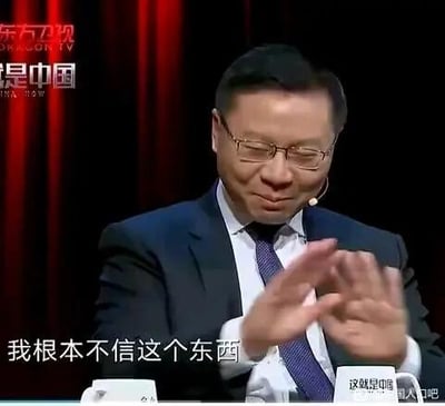 东方卫视《这就是中国》节目截图，画面中一名身着深色西装、白色衬衫并系紫色领带的男子坐在桌前，面前配有麦克风。他双手抬起作强调状，表情严肃且坚定，画面底部字幕显示其发言内容为'我根本不信这个东西'。左上角可见'东方卫视'和'这就是中国'的节目标识，右下角有水印'这就是中国人民吧'。