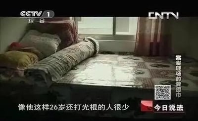 这是央视一套《今日说法》的节目截图，画面呈现了一个陈设简单的卧室，床上的被褥被卷成棍状随意放置。图中的字幕“像他这样26岁还打光棍的人很少”和画面形成双关梗：原本“打光棍”指单身，结合画面里的棍状被褥，被网友解读为“真的打棍子”，和原本的含义形成反差，制造出搞笑的调侃效果，右侧还有字幕“案发现场的带血围巾”点明节目案件背景。