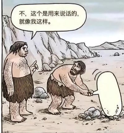 这是一幅搞笑手绘漫画，场景设定在原始人生活的荒地上：一个弯腰的原始人把现代的麦克风当成锤子，正用它砸地上的石头；旁边站立的原始人则伸出手指，严肃地纠正他，说道“不，这个是用来说话的，就像我这样。”。
笑点在于原始人对现代物品的完全误解，将麦克风的用途和锤子混淆，形成了荒诞的反差感，让人觉得滑稽好笑。