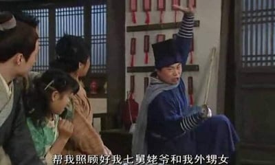 这是国产情景喜剧《武林外传》的经典场景截图，图中范明饰演的邢育森（邢捕头）身着捕快服饰，摆出夸张的姿势：单腿抬起，一手高举，一手拄着剑，表情激动地对着身旁的人喊出「帮我照顾好我七舅姥爷和我外甥女」这句台词，旁边的人露出惊讶的神情看向他。这句台词是邢捕头在假装受伤时的搞笑夸张嘱托，充满喜剧效果，后来成为网络热门梗，常被用来玩梗，表达夸张的托付或者搞笑的甩锅情绪。