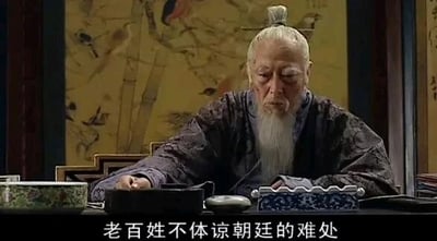 这是一张历史题材古装剧《大明王朝1566》的剧照截图，画面中是由演员倪大红饰演的明朝权臣严嵩，他白发白须，身着带有暗纹的深色古装，坐在摆放着文房器物的桌前，神情凝重且带着疲惫感，低头看向桌面，似乎正处于感慨或忧虑的情绪中。画面底部配有白色字幕“老百姓不体谅朝廷的难处”，这句台词是严嵩在剧中相关剧情里的发言，对应剧中朝廷与百姓存在矛盾的剧情场景，展现了该角色的立场以及当时的剧情氛围。