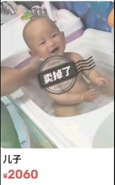 这是一张充满趣味的P图作品，画面主体是一个正在浴盆里开心洗澡的小宝宝，一只手轻碰宝宝的脸颊，宝宝露出开心的笑容。画面中央添加了模仿二手交易平台闲鱼的「卖掉了」样式贴纸，画面下方标注着「儿子 ¥2060」的文字，整体模仿二手商品交易完成的展示形式，以玩笑的口吻营造出「把儿子当商品卖掉」的搞笑效果，是家长用来调侃育儿辛苦、释放带娃压力的趣味玩梗内容。