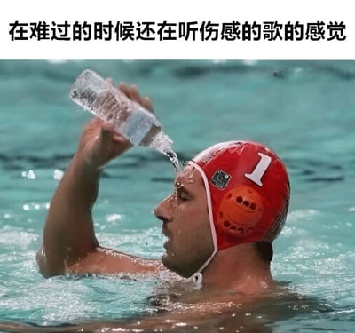 图片上方配有文字'在难过的时候还在听伤感的歌的感觉'，下方是一名戴着红色1号头盔的水球运动员在泳池中，正将手中的水瓶举过头顶往头上浇水，水花四溅。通过运动员在水中却仍用水瓶浇水的场景，幽默比喻人在难过时反而听伤感歌曲，如同在水中却还要加水，强化悲伤情绪的矛盾行为，引发共鸣。