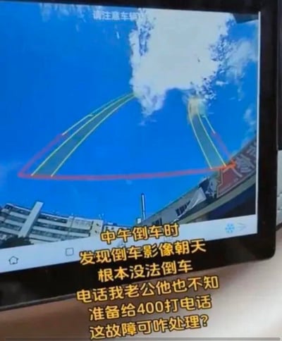 这是车主拍摄的车载倒车影像屏幕画面，画面中倒车影像的镜头朝向天空，只能看到蓝天、白云和远处的普通建筑，倒车辅助线也指向天空，完全无法起到辅助倒车的作用。下方配有文字说明自己遇到的故障困境，询问该如何处理。
无谐音梗、双关或暗示内容。