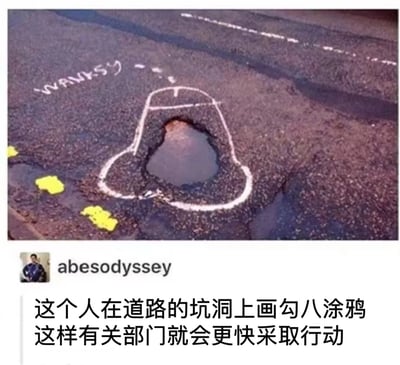 图片展示了一处路面上的坑洞，有人用白色粉笔在坑洞周围画了一个阴茎形状的轮廓，巧妙地将坑洞变成了阴茎的头部。左上角有类似签名的文字"WANKSY"，明显是对著名街头艺术家Banksy的戏仿。图片下方配有文字说明："这个人在道路的坑洞上画勾八涂鸦 这样有关部门就会更快采取行动"，暗示这种不雅但引人注目的涂鸦能促使政府部门更快修复道路问题。