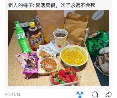 这是一张社交媒体分享的实拍美食图，图片顶部配文“狙人的蜂子:复活套餐，吃了永远不会死”，浅色木质桌面上摆放了多种食物：有麦当劳的汉堡、带品牌标识的冰饮、两个麦当劳牛皮纸打包袋，还有瓶装雪碧、康师傅冰红茶、两袋巧乐兹冰淇淋、一盒新鲜草莓、一碗盛有黄色咖喱类食物的餐碗，整体餐食种类丰富。图片左下角标注发布时间为“今天19:12”，底部有社交平台的评论、分享等互动按钮，发布者用夸张调侃的说法将这顿餐食命名为“复活套餐”，表达对这份餐食的喜爱和食用后能获得充足满足感的调侃。