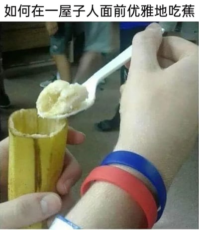 这是一张充满创意的搞笑梗图，顶部配有文字“如何在一屋子人面前优雅地吃蕉”。图中展示了一种新奇的吃香蕉方式：将香蕉皮从侧面纵向划开，保留完整的香蕉皮作为“容器”，一只手握住这个特殊容器，另一只手拿着塑料勺子，挖取容器内的香蕉肉。人物手腕佩戴着红蓝两色硅胶手环，背景中可以看到模糊的其他人，呼应了“一屋子人”的场景。这种夸张的创意吃法，以调侃的方式化解“公共场合吃香蕉不够优雅”的小尴尬，用荒诞的设定制造幽默效果，属于趣味生活类的搞笑内容。