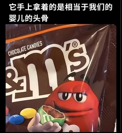 图片展示了M&M's巧克力糖果包装袋的特写，红色M&M豆人角色手持一颗被咬开的绿色M&M豆，露出内部巧克力。图片顶部有白色文字：“它手上拿着的是相当于我们的婴儿的头骨”。该 meme 通过拟人化手法，将被咬开的绿色M&M豆幽默夸张地比作人类婴儿的头骨，制造出滑稽有趣的效果。