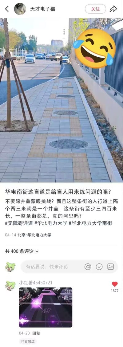 这是一张小红书平台的社交媒体截图，内容为用户“天才电子猫”发布的吐槽内容：配图拍摄的是北京华北电力大学附近华电南街的人行道，其中黄色的盲道线路上每隔两三米就设置有一个圆形井盖，井盖完全阻断了盲道的连续通行路径，发布者配文讽刺该盲道仿佛是用来给盲人练习闪避、进行蒙眼不踩井盖挑战的设施，质疑这条长三四百米的无障碍通道设计完全不合理，还附带了相关话题标签。该内容的评论区有用户“小红薯45450721”发布了一张音乐游戏的下落式按键界面截图，界面上的按键排布和盲道上的井盖排布高度相似，以此玩梗呼应吐槽，该评论获得1877个点赞，还得到了原帖作者的点赞认可。