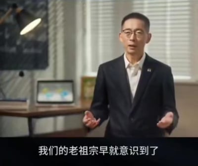 这是一段知识分享类视频的截图，画面中知名学者施一公身着深色西装搭配白衬衫，站在带有办公桌、电子设备的室内场景中，双手摊开，神情严肃认真地进行讲解，画面下方配有字幕“我们的老祖宗早就意识到了”，整体场景偏向正式的知识科普氛围，无谐音梗或双关含义。