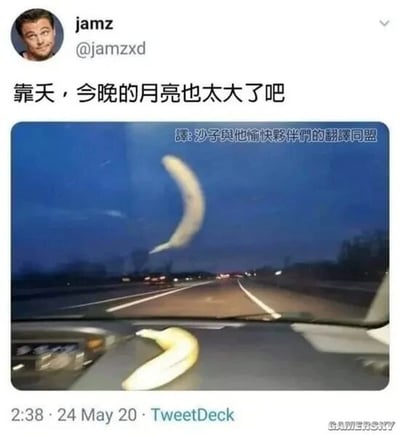 这是一张来自Twitter（现X平台）的社交媒体截图，用户jamz（@jamzxd）以莱昂纳多·迪卡普里奥的头像发布了这条趣味内容。推文配文“靠天，今晚的月亮也太大了吧”，配图是从汽车内部前挡风玻璃视角拍摄的夜景：夜空中看似巨大的弯月，实际上是放置在汽车仪表盘上的香蕉，利用近大远小的视觉错位效果，将近处的香蕉伪装成远处夜空中的超大月亮，制造出荒诞搞笑的反差感。画面中上部有翻译组的水印“譯:沙子與他愉快夥伴們的翻譯同盟”，右下角有“GAMERSKY”（游戏星空）的水印，说明该内容被相关网站转载过。整个内容通过视觉错觉制造笑点，属于典型的趣味梗图类社交媒体内容。