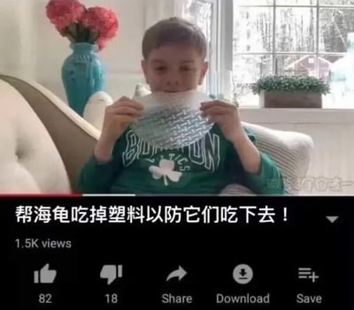 这是一张短视频截图，上半部分画面是一名穿着印有三叶草图案绿色上衣的小男孩坐在室内沙发上，双手举着一块透明塑料网格制品放在嘴边作势要吃，背景可见摆放着红色花束的蓝绿色花瓶、窗边绿植等家居陈设；下半部分是视频的交互界面，标注了1.5K播放量，还有点赞、点踩、分享、下载、保存的功能按钮，显眼配文写着“帮海龟吃掉塑料以防它们吃下去！”，内容用完全违背常识的荒诞逻辑演绎所谓的“环保行为”，制造出搞笑的吐槽效果。