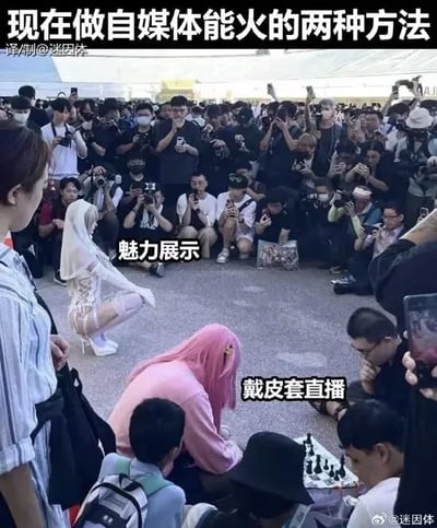 图片展示了一个拥挤的户外场景，大量人群举着手机和相机拍照。画面中心有两位人物：一位身着白色透视装、白色长袜的女性单膝跪地，摆出性感姿势，标注为“魅力展示”；另一位粉色头发的人弯腰面向地面，标注为“戴皮套直播”。图片顶部配有文字“现在做自媒体能火的两种方法”，以幽默的方式讽刺了当下自媒体行业中依靠外貌吸引眼球和扮演虚拟形象进行直播的现象。