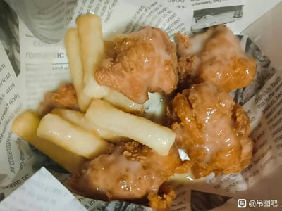 📸 特写镜头下的炸鸡盛宴！金黄酥脆的炸鸡块裹着晶莹的糖霜，旁边堆着雪白的粗薯，全都躺在印满英文报纸文字的包装纸上，油光锃亮让人食欲大开～