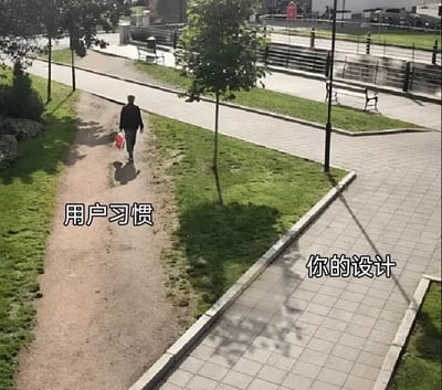 一张公园场景的照片，展示一名行人提着红色袋子，正沿着一条被踩出来的泥土小径行走（图中左侧标注“用户习惯”），而旁边铺设整齐的石板路（图中右侧标注“你的设计”）却被忽略。这一画面幽默地隐喻了用户在实际使用中往往会根据自身习惯选择“捷径”，而非遵循设计者规划的“正规路径”。背景可见绿树、长椅和开阔的广场，阳光明媚，整体场景贴近日常生活。