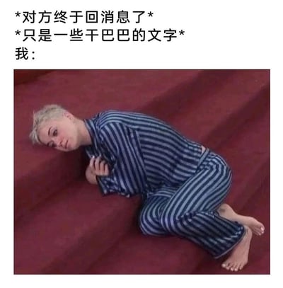 这是一张贴合社交情绪的表情包，上方配文描述了“等待对方回复许久，终于收到消息却只是干巴巴的文字”的场景，下方是美国歌手凯蒂·派瑞侧躺在红色沙发上的画面：她穿着蓝白条纹睡衣，身体蜷缩、双手抱胸，神情低落蔫蔫的，眼神透着失落感，精准还原了人们在社交中满心期待却得到敷衍回复后的失落、无力的心情，很容易引发共鸣。
