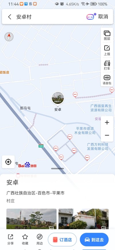 这是一张百度地图手机端的截图，显示了位于广西壮族自治区百色市平果市的“安卓村”地理位置。地图界面中可见多个红色标记点，周围标注有“广西万利科技发展有限公司”“平果市德源木业有限公司”“广西靖夏再生资源有限公司”等企业名称，以及“那马屯”“铝饭店”等地名。屏幕底部展示了安卓村的详细地址信息，并配有两张村庄实景缩略图，下方还有“分享”“收藏”“周边”“订酒店”“到这去”等功能按钮。