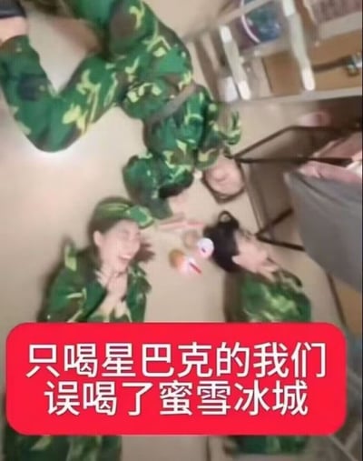 图片中几名身穿绿色迷彩服的年轻人躺在室内地板上，表情夸张，呈现出搞笑的反应状态。画面底部有红色背景白色文字的横幅，内容为“只喝星巴克的我们误喝了蜜雪冰城”，通过对比高端咖啡品牌与平价茶饮品牌，制造出一种反差幽默，可能用于调侃不同消费层次的观念或进行轻松的品牌对比搞笑内容。