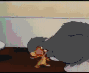 这是出自经典动画《猫和老鼠》的GIF动态截图，画面中汤姆用自己的大脸颊死死压住小老鼠杰瑞，杰瑞露出窘迫又无奈的表情，身体被完全固定住无法动弹。这个场景生动地呈现出被拿捏、身不由己的状态，常被用作表情包来表达自己处于被动、被压制的无奈处境。