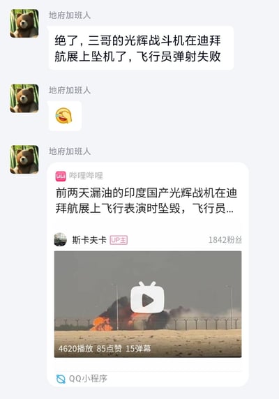 这是一段QQ聊天记录截图，用户「地府加班人」分享了印度国产光辉战机在迪拜航展坠毁的相关消息：先是用文字说明「绝了，三哥的光辉战斗机在迪拜航展上坠机了，飞行员弹射失败」，并配上捂脸笑的表情，随后转发了哔哩哔哩UP主「斯卡夫卡」的相关视频，视频标题提到该战机此前还出现漏油情况，视频截图展示了坠机后的起火爆炸现场。内容无谐音梗、双关或暗示。