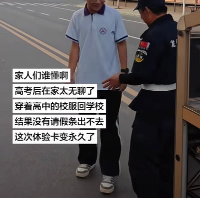 这张实拍静态图取景于学校门口的道路区域，画面中共有两人，左侧是一名穿着浅蓝色高中校服、戴眼镜的年轻男生，他正笑着看向右侧的保安；右侧是穿着深蓝色制服的学校保安，正伸手做出阻拦的动作。画面左侧叠加了白色背景的黑色配文，是当事人的吐槽内容：高考结束后在家太过无聊，就穿着以前的高中校服回学校逛逛，结果出校门的时候被保安误认为是在校学生，要求出示请假条，没有假条就没办法出去，调侃自己这次的返校体验卡直接变成了永久留校卡，整体事件充满搞笑的反差感。