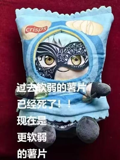图片展示了一个蓝色的毛绒玩具，其造型模仿薯片包装袋，顶部印有“crisps”字样。玩具正面设计有一个卡通角色形象，该角色戴着黑色花纹面具，拥有金色的大眼睛和微笑的表情，显得十分可爱。图片右侧叠加了白色中文文字：“过去软弱的薯片已经死了！！现在是更软弱的薯片”，通过幽默的反差手法，将薯片“软弱”的特性夸张化，营造出搞笑的效果。