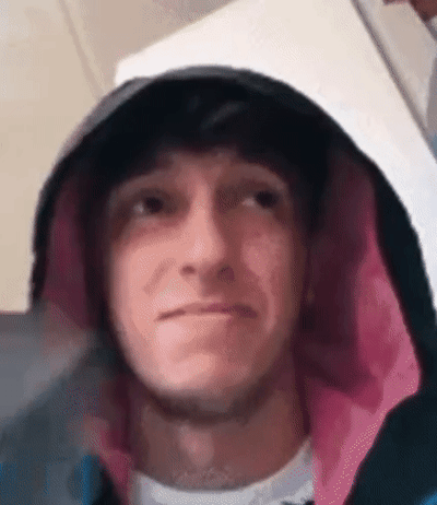 一位穿着带粉色内衬兜帽衫的男子，小心翼翼地将一只灰色小猫藏在兜帽里。他用手指轻轻托着小猫，先将它靠近自己的鼻子，再移到脸颊旁，最后放在下巴处亲昵互动。男子全程面带微笑，眼神温柔，而小猫则乖巧地蜷缩在他手中，显得十分舒适惬意。整个画面充满了温馨治愈的氛围，展现了人与宠物之间的亲密情感。