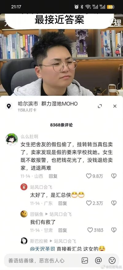 图片为社交媒体评论区截图，顶部显示一名戴眼镜、短发的男性坐在书架前（背景有书籍和手办），下方是定位为“哈尔滨市 群力湿地MOHO”的评论区。核心评论由用户“么么肚啊”发布，讲述女生偷舍友假包挂转转平台当正品售卖，买家发现假货后欲到校追责，女生因已花光钱款且不敢报警而进退两难。下方热评“站风口会飞”调侃“太好了，是汇总是侠😂😂”，引发其他用户跟风玩梗“我们有救了”，形成幽默讽刺的评论氛围。