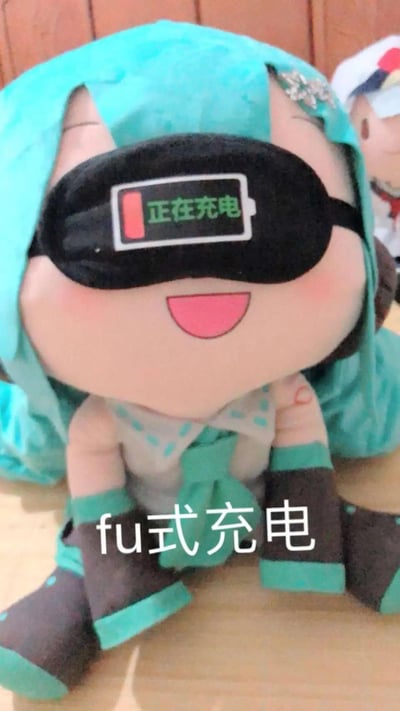 这是一张初音未来的fufu趴趴毛绒玩偶的趣味照片，玩偶被戴上了印有“正在充电”电池图案的黑色眼罩，玩偶本身是开心大笑的表情，下方配文“fu式充电”。
这里运用了谐音梗：“fu”对应fufu的昵称，将玩偶的休息状态拟人成电子设备充电，把自己休息补充精力的状态用可爱的ACG玩偶来表达，十分治愈有趣。