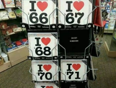 商店货架上摆放着一系列‘I ❤️ [数字]’样式的标牌，数字依次为66、67、68、70、71等，唯独数字69的位置被黑色的‘SOLD OUT’标牌取代，暗示该数字标牌因特殊含义而热销一空。画面背景可见商店内的其他商品，整体场景真实自然。