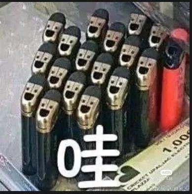 这是一张静态横版的原始拍摄图，画面中多支黑色打火机整齐排列，因视觉错位效果，打火机的顶部和机身组合起来看起来像是一群有着统一“人脸”的形象，画面下方配有醒目的白色“哇”字，用来传递看到这个趣味视觉效果时的惊讶、惊奇情绪，属于利用视觉错觉制作的趣味梗图。