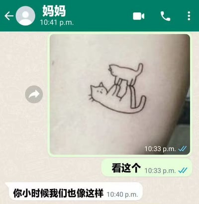 这是一张展示WhatsApp聊天截图的梗图，聊天双方是“妈妈”和子女，图片内容是一枚简笔画风格的猫咪纹身，画中两只猫一只躺着，另一只猫踩着它的肚子。子女发图说“看这个”，妈妈则回复“你小时候我们也像这样”，幽默地将猫咪的互动类比为小时候的亲子互动场景。

该图借助可爱的猫咪纹身与亲情话题反差带来幽默效果，适合表达家庭日常和怀旧感。
