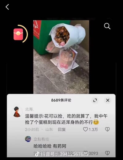 这是一张抖音平台的视频评论截图，视频画面显示垃圾桶旁被丢弃的包装花束和带透明包装的蛋糕。评论区高赞用户“北海.”留言：“温馨提示:花可以捡，吃的就算了，我中午捡了个蛋糕到现在还浑身热的不行😜”，另一用户“立刻有哇”回复“哈哈哈哈 有药阿”，用玩笑的方式调侃捡食不明来源食物可能存在的风险，引发大量网友互动，评论数达8689条。