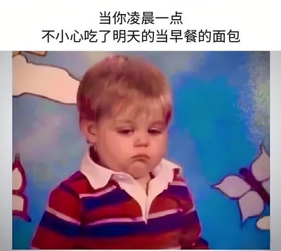 图片上方配有文字“当你凌晨一点不小心吃了明天的当早餐的面包”，下方是一张小孩的照片。照片中的小孩有着金色短发，穿着红紫相间的条纹上衣，背景为蓝色带有白色蝴蝶装饰。小孩眉头微皱，嘴角下撇，眼神低垂，呈现出明显的悲伤和懊悔表情，完美呼应了文字所描述的因深夜误食次日早餐面包而产生的懊恼心情。