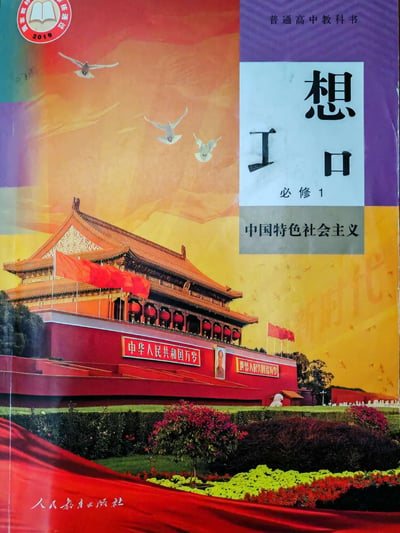 这是一张经过网友恶搞修改的普通高中教科书《思想政治必修1 中国特色社会主义》封面图，原本封面的“思”字被拆分修改为“Ⅰ口”，与右侧的“想”字组合成带有视觉趣味的文字效果。封面主体为北京天安门的实景画面，搭配飞翔的和平鸽，背景是暖色调的天空，底部标注了人民教育出版社的名称，左上角有2019年国家教材审核通过的标识。