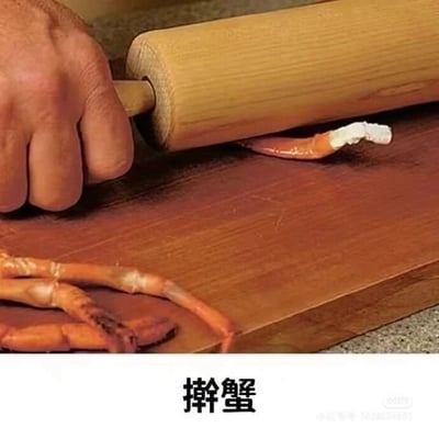 这是一张文字加注的静态单图，画面呈现了一只手握着木质擀面杖，在木质案板上擀压一块蟹钳，案板上还放置着其他蟹腿部位。图片下方配有文字“擀蟹”，利用中文谐音，“擀蟹”与“感谢”发音相近，是网友创作的趣味梗图，通过将日常擀面的动作替换为擀蟹钳的荒诞场景，以幽默的方式来表达感谢的情绪，让原本普通的致谢变得更有创意和趣味性。