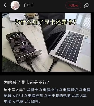 这是一张社交媒体内容截图，画面中桌面摆放着一台笔记本电脑，旁边放着一块台式机独立显卡，用户将显卡的供电线直接插在了笔记本的USB接口上，图上配文询问为什么加了显卡之后电脑还是卡顿，截图下方是发布者的提问文案以及多个和电脑、硬件相关的话题标签。该内容属于搞笑梗图，是不懂硬件常识的用户做出的常识性错误操作，台式机独立显卡无法通过这种简单插USB的方式连接笔记本正常工作，自然起不到提升电脑性能的作用。
