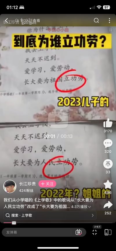 这是B站的视频截图，对比了2022年与2023年小学一年级教材中《上学歌》的歌词差异：2022年版本为“长大要为人民立功劳”，2023年版本修改为“长大要为祖国立功劳”，图中用红圈标注出两处歌词的不同部分，配文“到底为谁立功劳？”，引发网友对教材歌词修改的讨论。