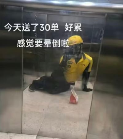 这是一张利用电梯金属面板反光形成的趣味视觉错位图，画面看起来像是一位穿着黄色美团外卖服的骑手瘫坐在电梯角落，身旁放着外卖餐盒，搭配文字“今天送了30单 好累 感觉要晕倒啦”，营造出外卖员极度劳累的状态。实际上这是反光造成的视觉错觉，并非真实的骑手累倒在电梯中，这类内容很容易引发打工人的共情，用搞笑又扎心的方式表达工作的疲惫。
没有双关或谐音梗，主要通过视觉错位制造趣味和共鸣。
