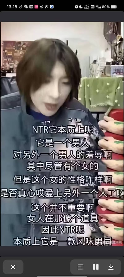 这是一段竖屏直播的画面截图，画面中的短发男主播正在发表对ACGN文化中NTR概念的颠覆性解读，字幕完整呈现了他的观点：将NTR定义为男人之间的羞辱行为，认为女性在其中如同道具，甚至调侃其本质是“风味男同”，观点十分出格，带有玩梗解构的意味，容易引发关注与讨论。