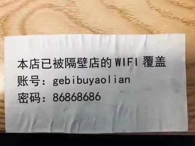 这是一张拍摄于木质桌面上的纸质告示，告示上以黑色字体标注了WiFi相关信息：首先写着“本店已被隔壁店的WIFI覆盖”，随后给出WiFi账号“gebibuyaolian”，密码“86868686”。其中账号“gebibuyaolian”是“隔壁不要脸”的拼音全拼，玩了谐音梗，用自嘲又调侃的方式整活，风格搞笑有趣，用这种趣味化的方式提供WiFi信息，能让看到的人印象深刻。