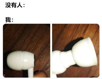 这是一张左右对比格式的梗图，上方文字分别为"没有人："和"我："。左侧图片显示一个普通的木质桌面，右侧图片则特写展示了一只白色的入耳式耳机放在相同的木质桌面上。通过对比手法幽默地表现了"没有人关心的普通场景"与"我特别关注的小事"之间的反差。