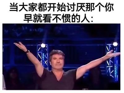 图片上方配有文字“当大家都开始讨厌那个你早就看不惯的人：”，下方是西蒙·考威尔在舞台上双臂张开的截图。他穿着深色上衣，背景为蓝色舞台灯光，表情得意，动作夸张，生动展现了当众人终于与自己有相同看法（讨厌同一个人）时的解气与兴奋感。