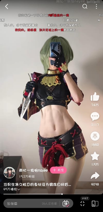 这是一张来自bilibili平台的cosplay照片截图，展示了一位穿着原神角色久岐忍服装的女性。她有着绿色短发，身穿黑色露脐装和紫色短裤，露出明显的腹肌线条。她左手拿着手机自拍，右手持有一把装饰性刀具。图片上方有文字评论，底部显示了创作者信息和互动数据。